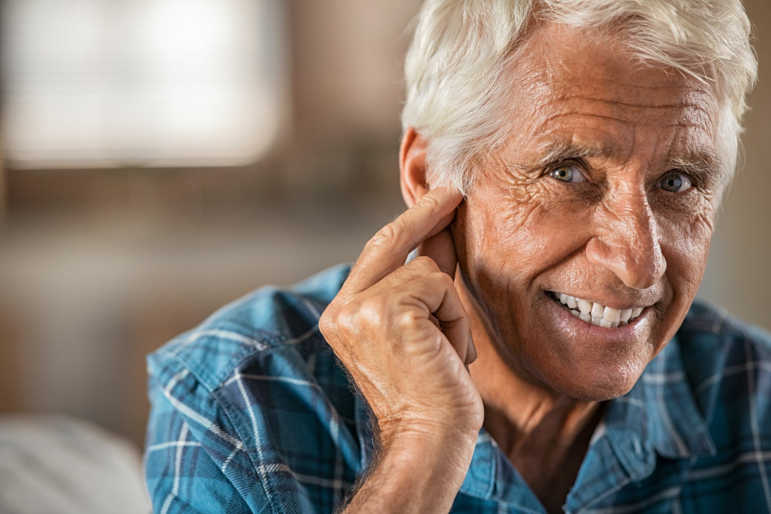 older man smiling with hearing