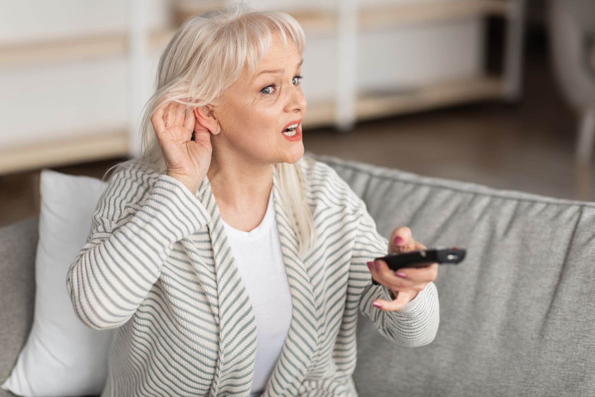 woman struggling to hear tv